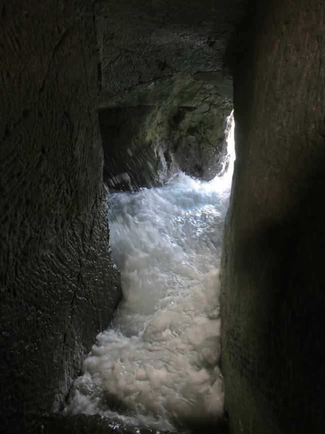 Acqua in rapido movimento tra pareti rocciose nella scoperta di un’antica grotta marina naturale.