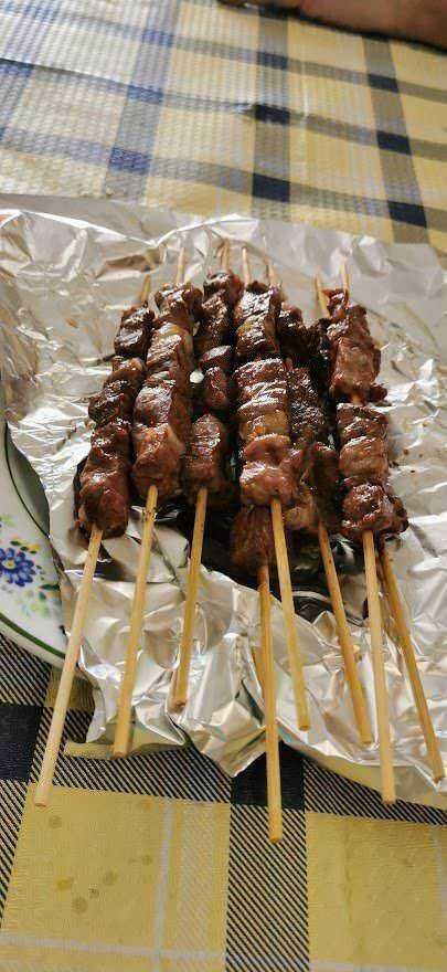 Succulenti spiedini di carne al barbecue serviti su carta argentata, perfetti per grigliate estive e ricette di carne gustose.