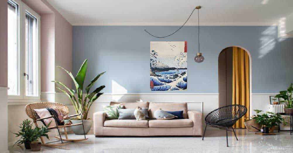 Luminosa zona living con salotto beige, piante verdi e decorazioni moderne in uno spazio accogliente e colorato.