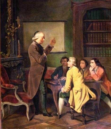 Immagine di un insegnante che spiega ai ragazzi in una classe storica con scaffali e camino.