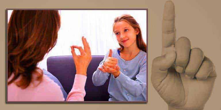 Mamma e figlia che praticano la lingua dei segni, segno dell'alfabetizzazione uditiva, comunicano in modo visivo per favorire l'inclusione e l'apprendimento della comunicazione alternativa.
