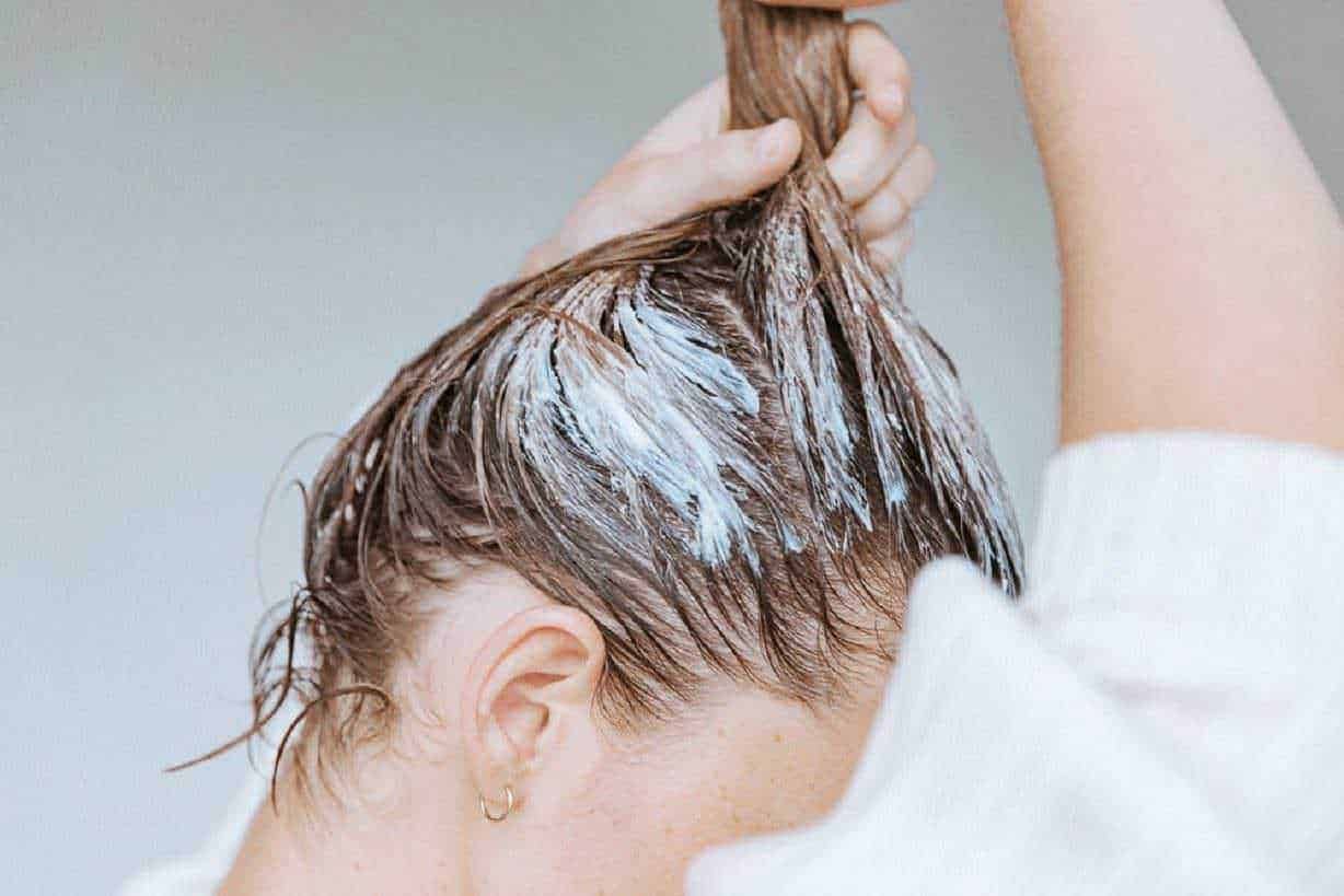 Capelli bagnati, donna che si lava i capelli con shampoo in uno stile di vita quotidiano e cura personale.
