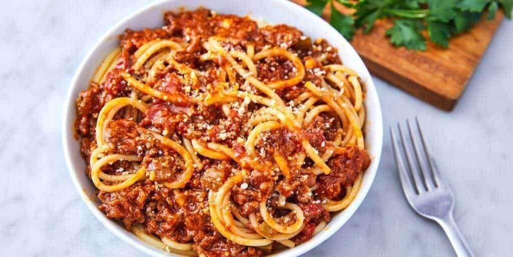 Deliziosa pasta spaghetti al ragù di carne, guarnita con formaggio grattugiato, perfetta per pasti ricchi e saporiti. Ideale per cene in famiglia o pranzi conviviali. Preparata con ingredienti freschi e autentici.