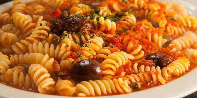 Pasta spaghetto con sugo di pomodoro, olive nere e basilico fresca, piatto tradizionale italiano, cibo italiano autentico, ricetta italiana classica, spaghetti al pomodoro, cucina italiana genuina.