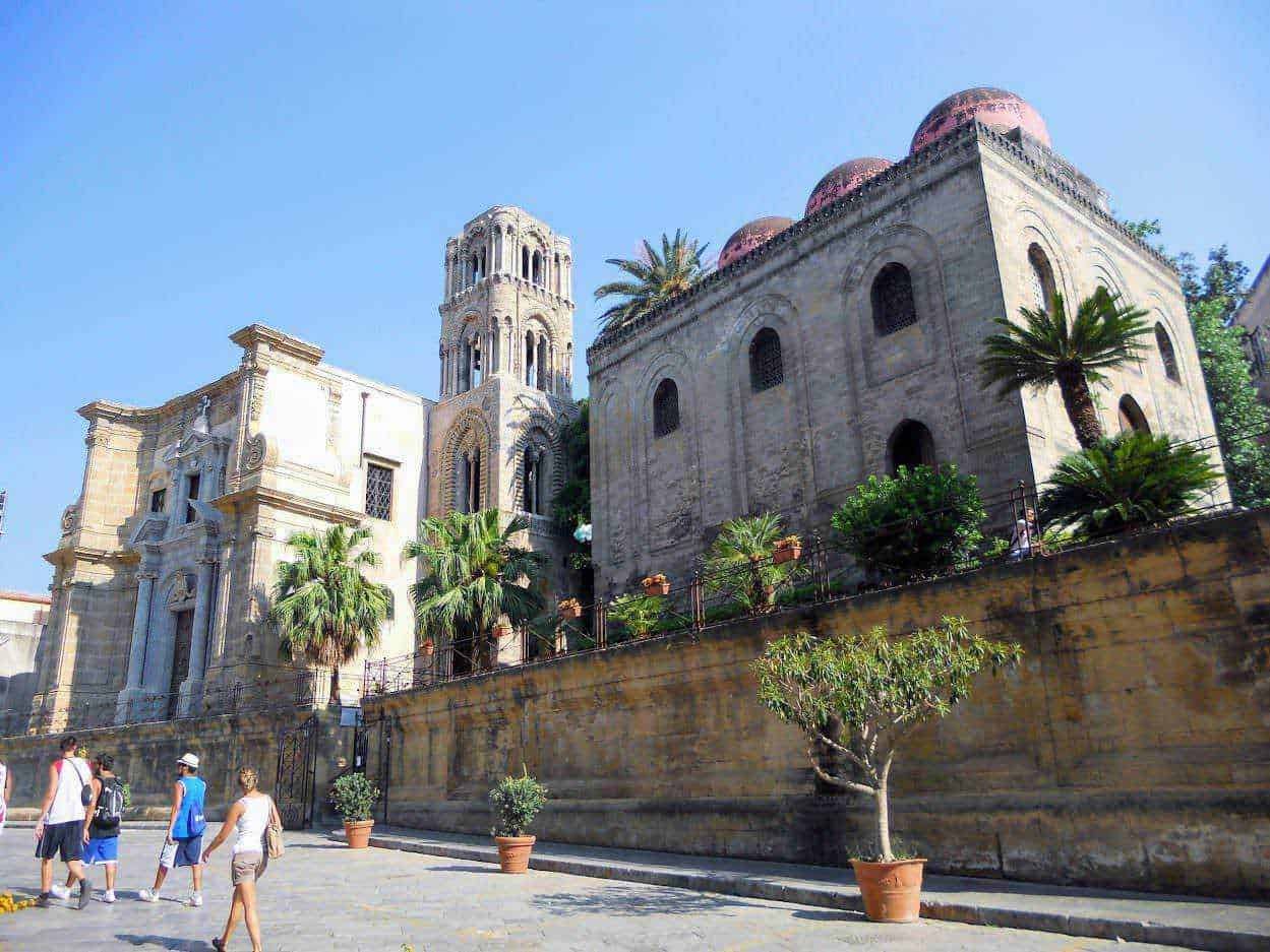 Antico monastero in stile barocco con piante di palma e decorazioni architettoniche dettagliate a Napoli, Italia. Un'icona storica e culturale, perfetta per apprezzare l'arte e la storia italiana.