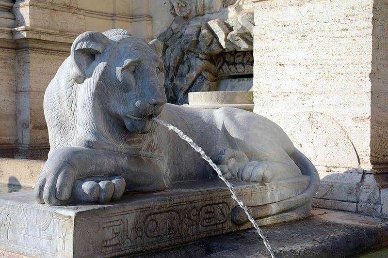 Sfinto del leone di pietra con getto d'acqua, fontana storica in Piazza del Campidoglio a Roma, simbolo di forza e regalità, monumento affascinante e originale.