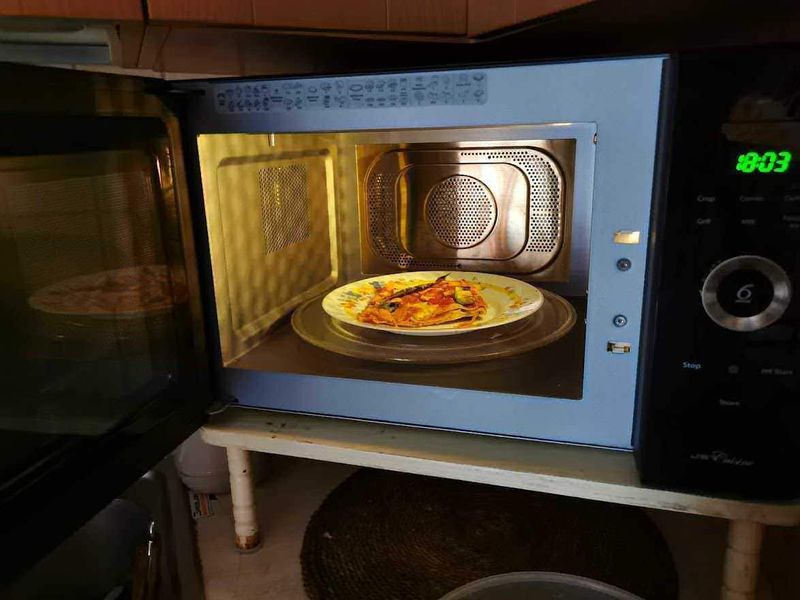 18 Modi di risparmiare energia elettrica 5 Piatto di pizza riscaldato nel microonde, cucina moderna, microonde acceso, cibo caldo, preparazione pasti, tecnologia da cucina, alimenti pronti, linea domestica, elettrodomestici moderni, cibo italiano, alimentazione salutare, cucina casalinga, ricette italiane, comfort culinario, attrezzature da cucina di alta qualità, apparecchiature per il riscaldamento, ambiente cucina accogliente, style di vita, alimenti pronti in modo rapido, innovazione culinaria.