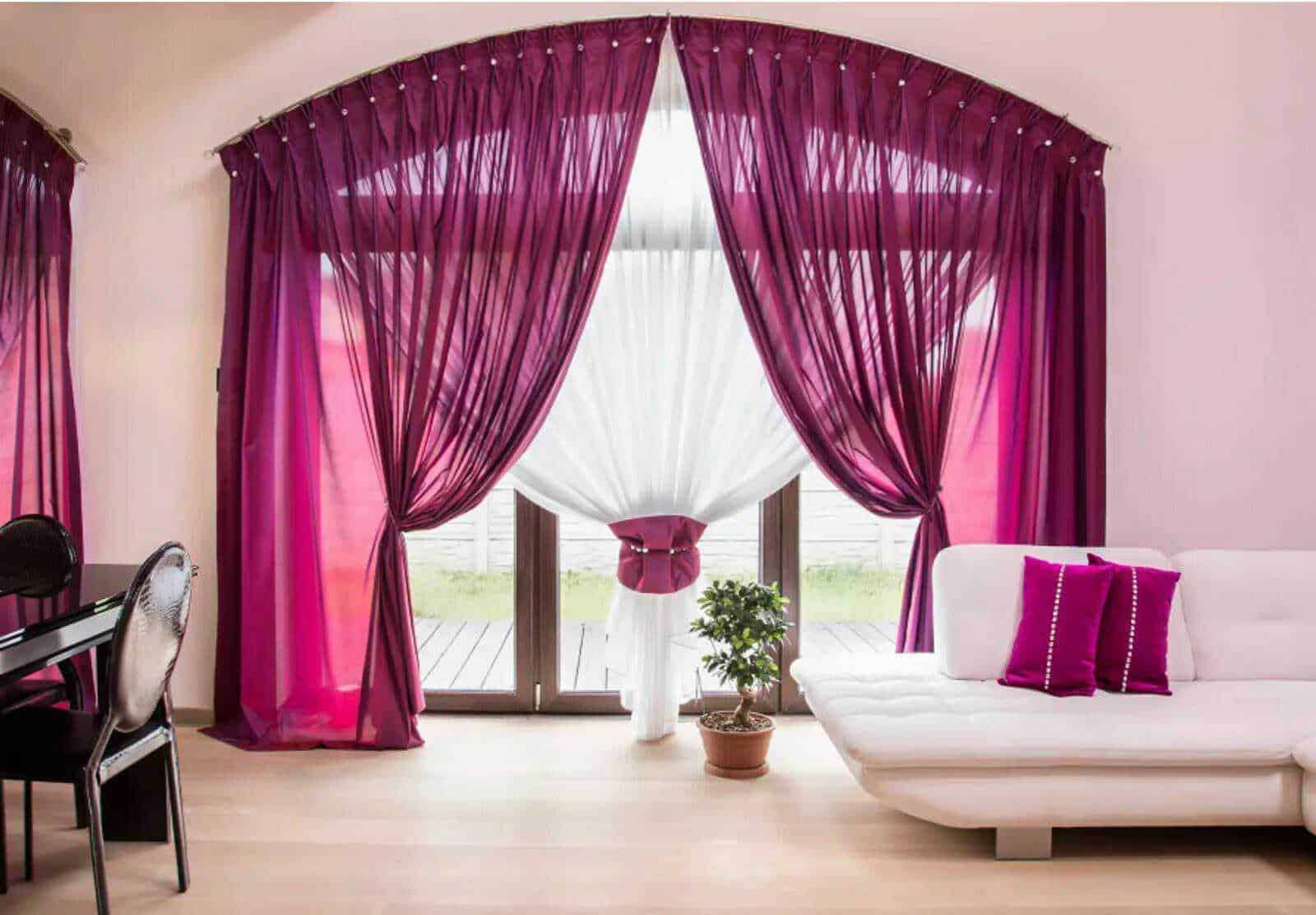 Colorate tende viola e bianco in soggiorno con porta finestra, arredamento moderno con divano bianco e cuscini fucsia, decorazione di casa elegante e luminosa.