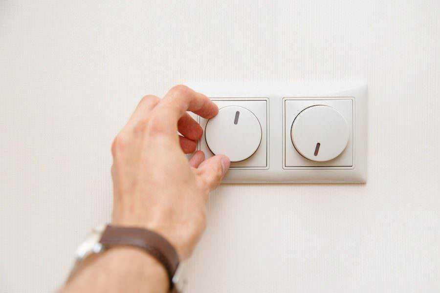 Interruttore della luce manuale, impianto elettrico domestico, controllo dell’illuminazione, immagine di un cambio di impostazioni luci, energia e risparmio domestico.