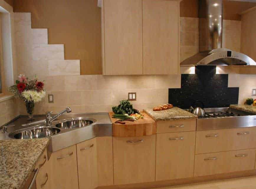 Fornello cucina moderno con pensili in legno e piani in pietra, ideale per preparare pasti domestici, con dettagli eleganti e funzionali.