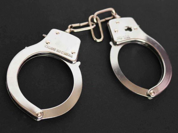 Quante perle nel bracciale, pari o dispari? 4 Manette di metallo placcato argento con catenella, simbolo di restrizione e sicurezza, su sfondo nero. Ideale per articoli riguardanti sicurezza, forze dell'ordine, o strumenti di controllo.
