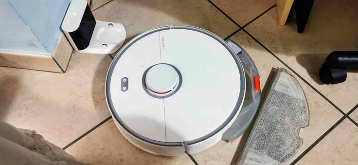 Robot Roborock S5 Max aspira e pulisce ogni ambiente 4 Robot aspirapolvere in funzione su pavimento in ceramica, dispositivo intelligente per la pulizia domestica, compatto e silenzioso.