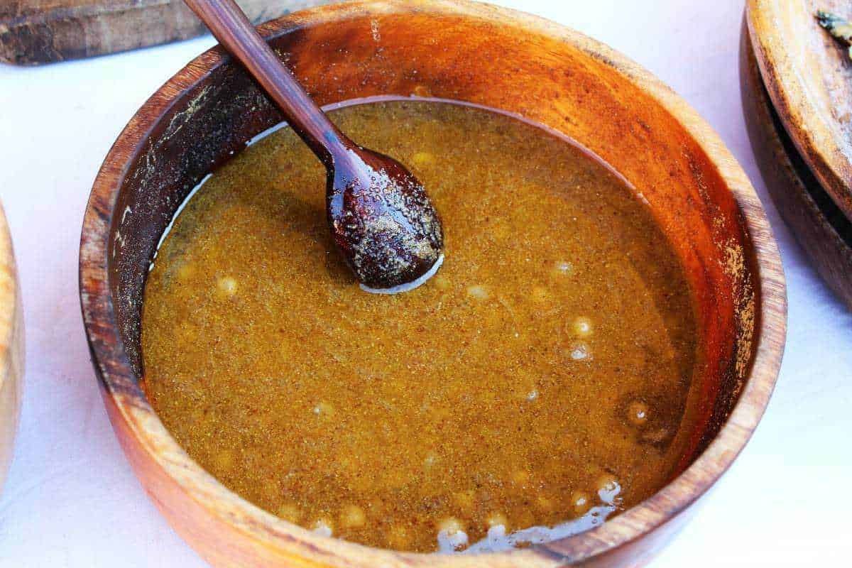 Salsa barbecue fatta in casa in una ciotola di legno, pronta per essere utilizzata come condimento per carne e piatti alla griglia. Perfetta per aggiungere sapore e gusto ai tuoi pasti all'aperto.