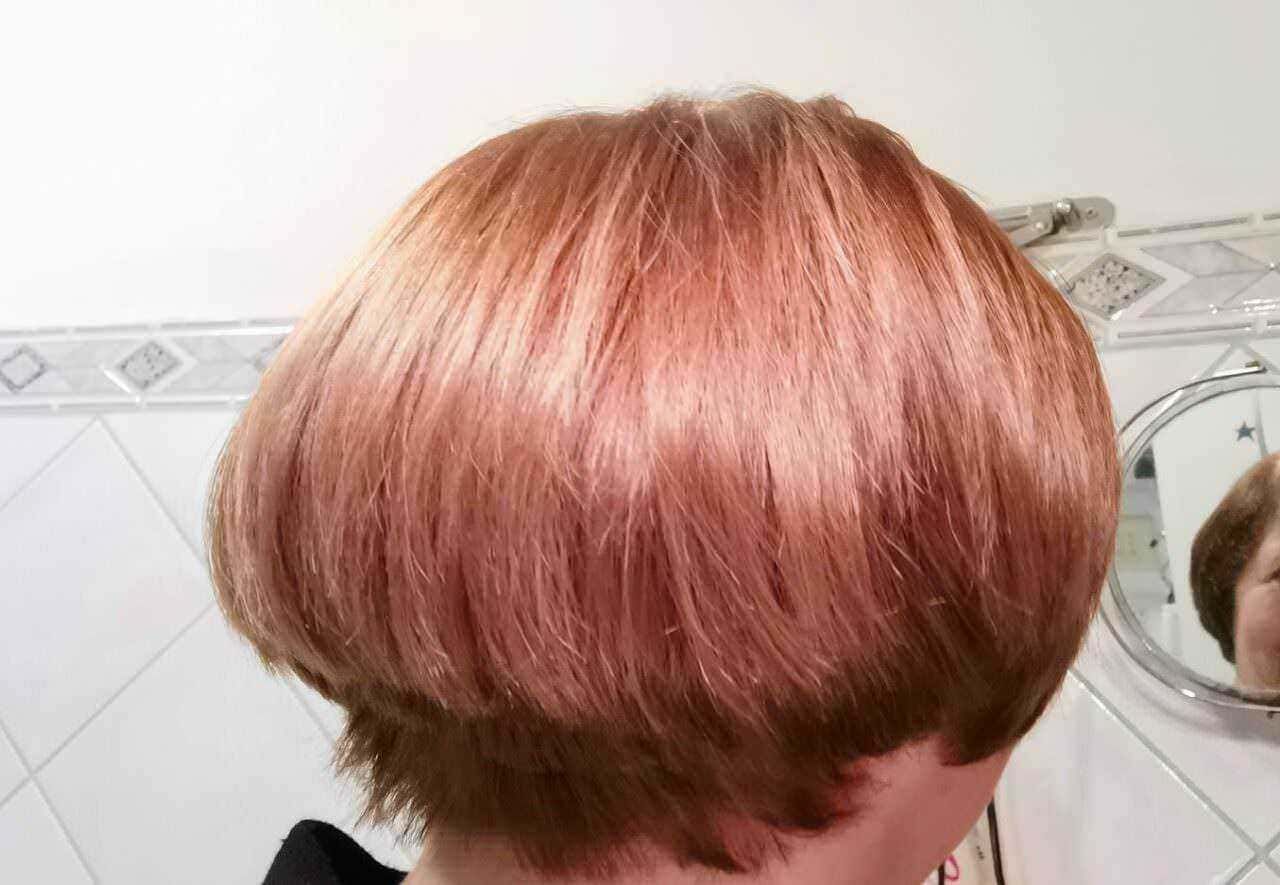 Lieve capelli cortissimi con sfumature di colore rosato, stile bob moderno, perfetti per un look alla moda e originale. Capelli lisci, ben curati, sotto la luce naturale.
