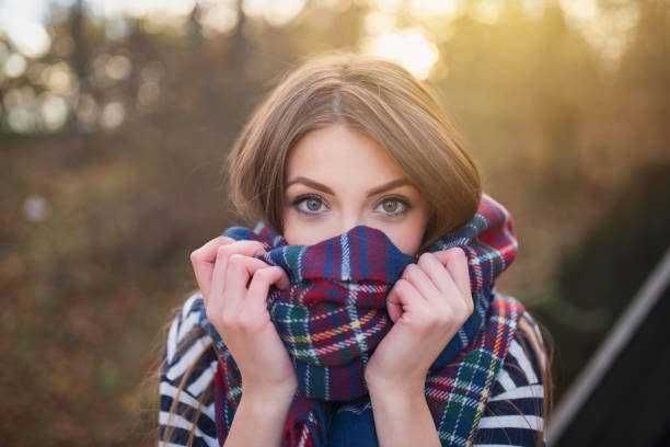 Abbraccio caldo di una donna con sciarpa a quadri, ambiente autunnale, atmosfera accogliente e protectiva. Perfetto per contenuti su moda autunnale, stile invernale e comfort stagionale.