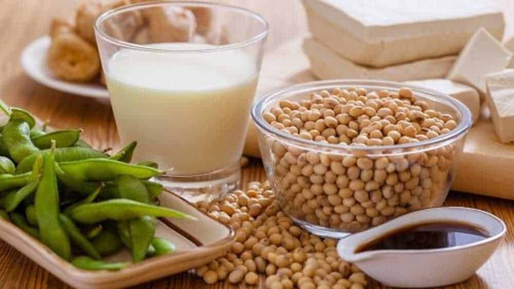 Sorgo di soia, latte di soia, edamame e salsa di soia su tavolo di legno, alimenti vegani e salutari, ingredienti per ricette a base di soia, cibo naturale, dieta vegetariana e vegana, alimenti proteici.