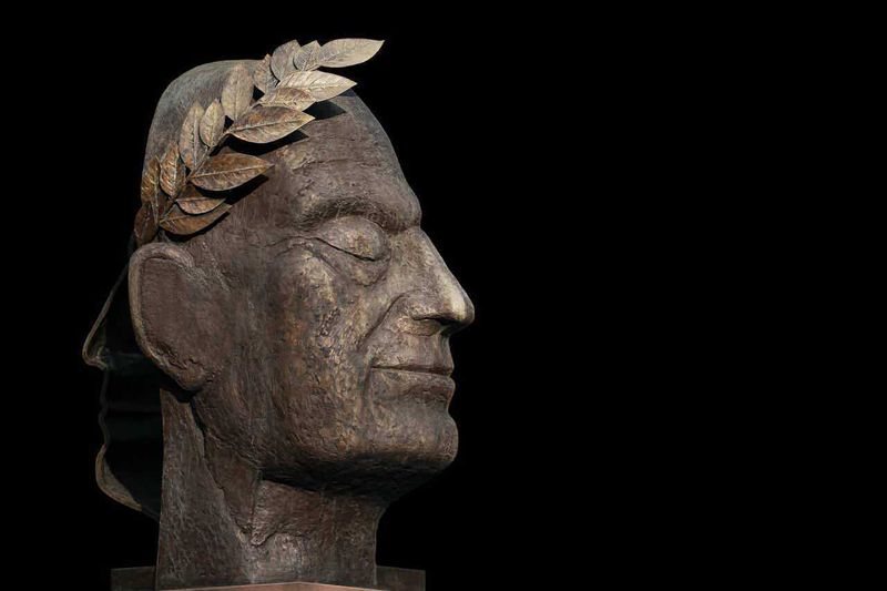 Circo Massimo Roma corse equestri ed eventi 2 Circo massimo di roma: Bronzo di una testa di anziano con foglie di alloro in testa, simbolo di saggezza e vittoria, su sfondo nero, rappresenta il rispetto delle persone anziane e l'importanza della memoria storica.