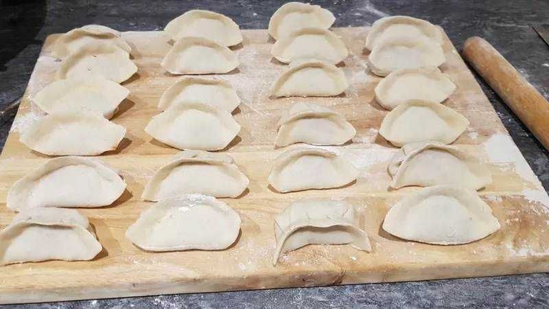Finocchi e ravioli fatti in casa su tagliere di legno, preparati per la cottura. Perfetto esempio di ricetta tradizionale italiana per pasta fresca, ideale per appunti sul blog di cucina italiana.