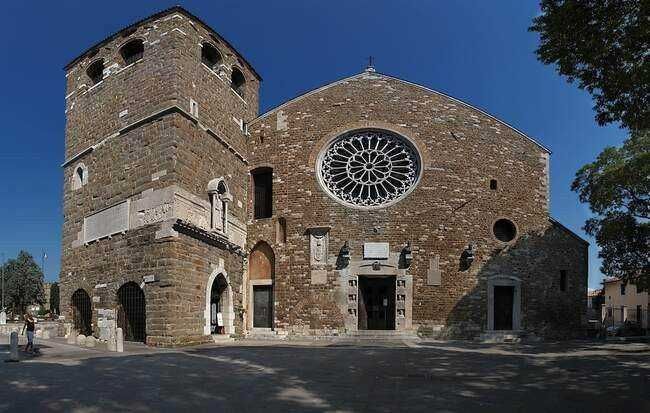 Antico teatro romano di Napoli con sedili in pietra e arena, esempio di archeologia e storia antica, visitabile e affacciata sulla città moderna.