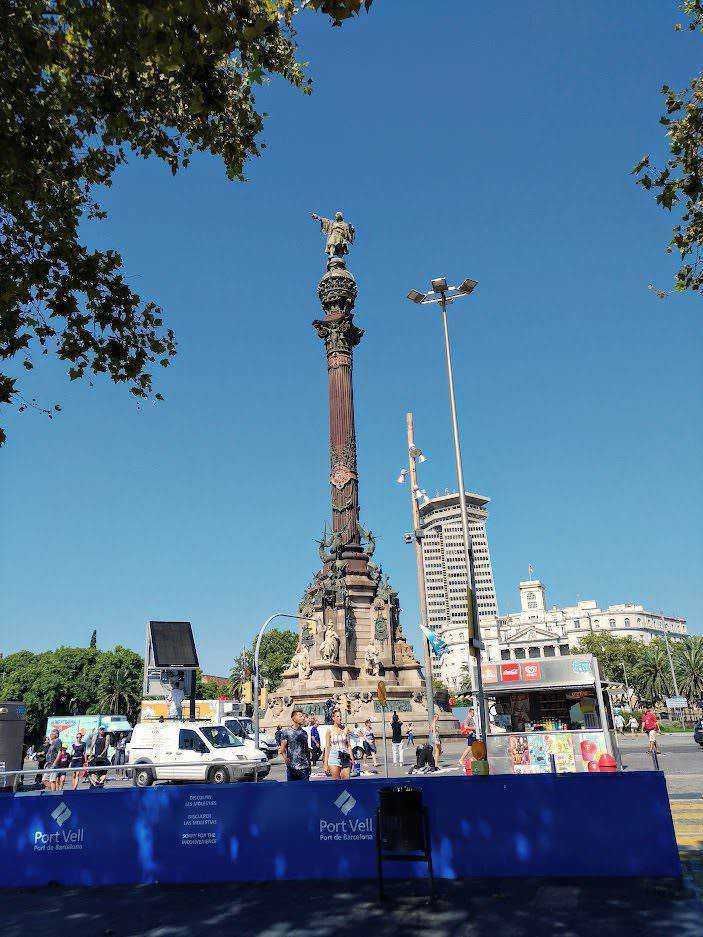 Colonna di Cervantes a Barcellona, monumento storico nel centro città, con cielo azzurro e turismo locale, simbolo culturale di Port Vell.