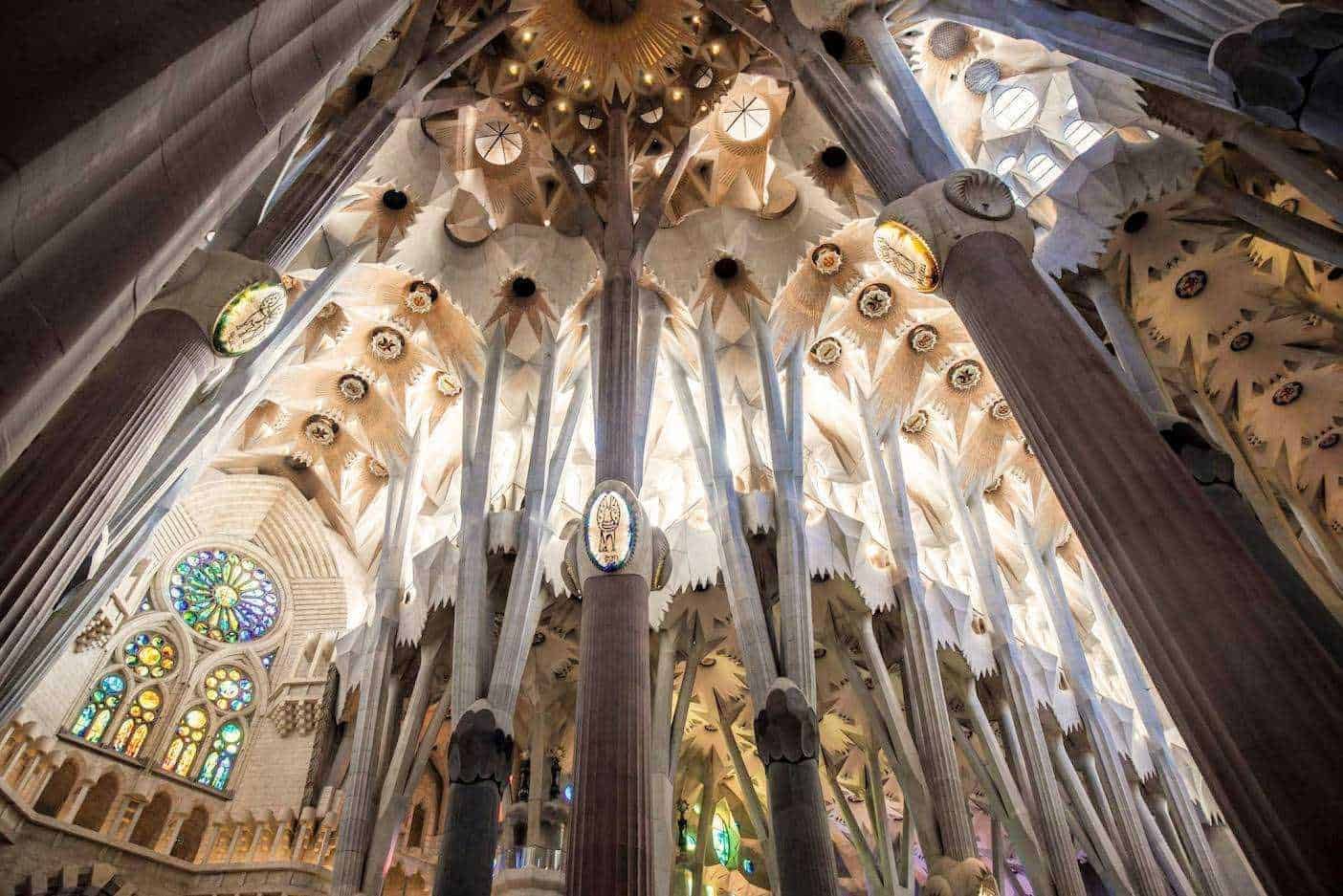 Fili di pietra e colonne della Sagrada Família, dettagli architettonici, interno della chiesa con vetrate colorate e soffitto elaborato, progettata da Antoni Gaudí, monumento di Barcellona, arte e architettura moderna.