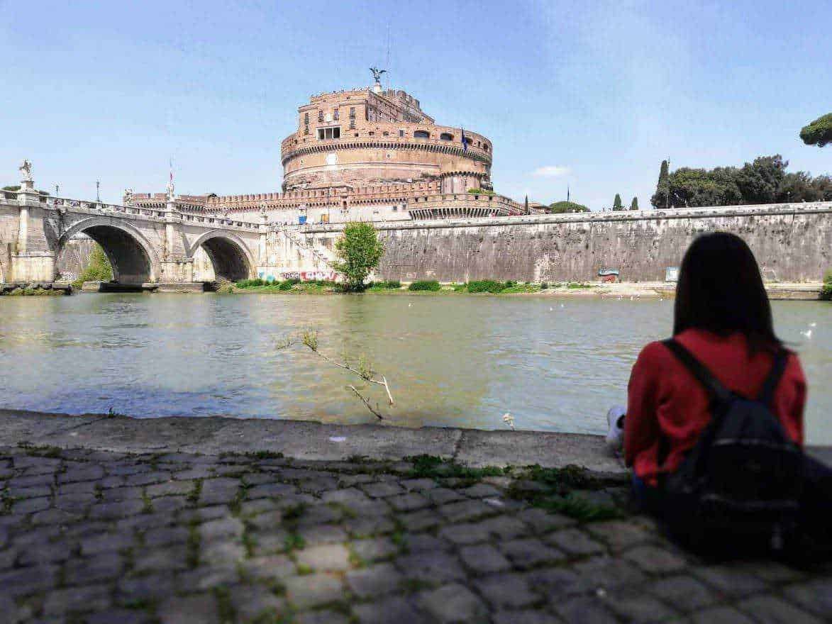 Castel Sant'Angelo e il Tevere a Roma, vista panoramica, turista seduta sul lungotevere, monumento storico e attrazione turistica, architettura romana, viaggio culturale.