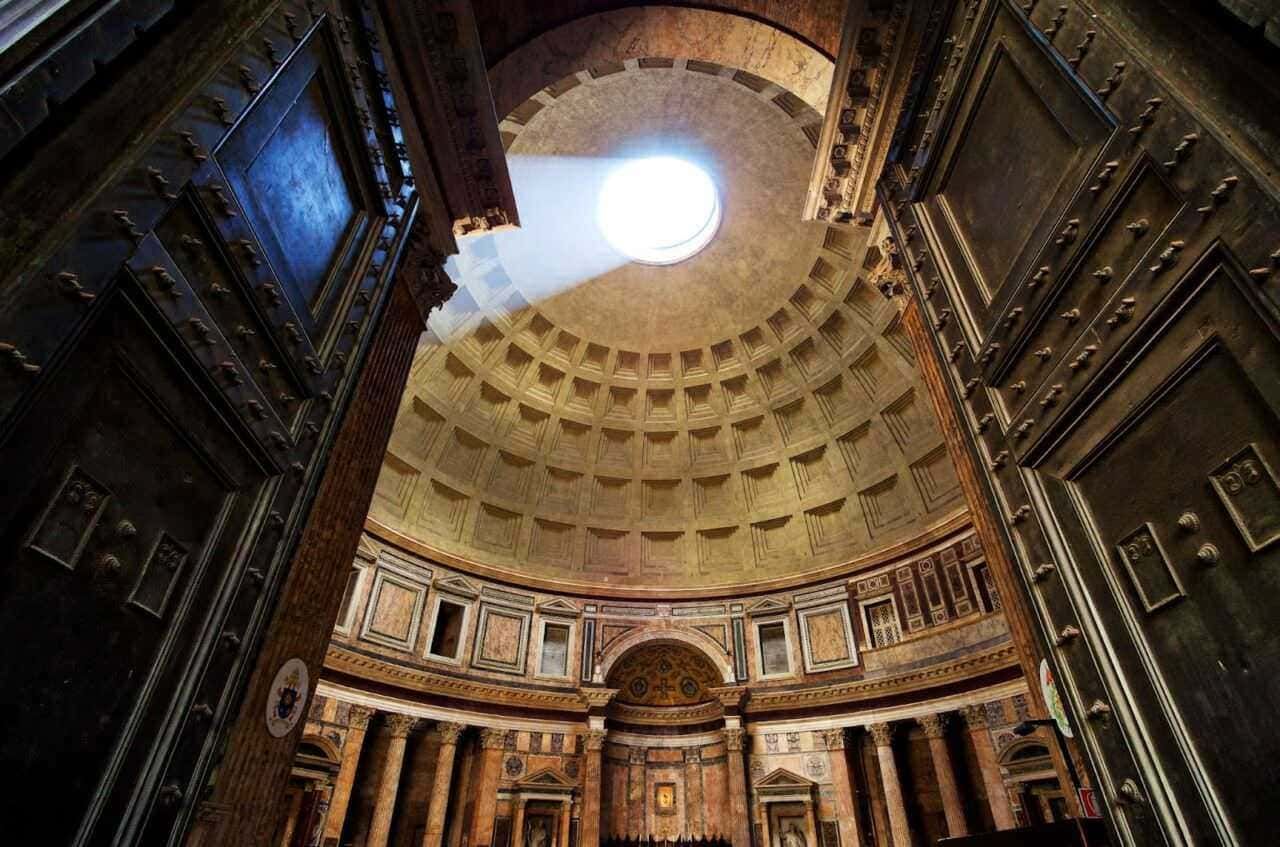 Lux in galleria del Pantheon, luce naturale attraverso oculus, architettura storica, interno maestoso, dettagli artistici e decorativi, monumento iconico di Roma, cattedrale antica.