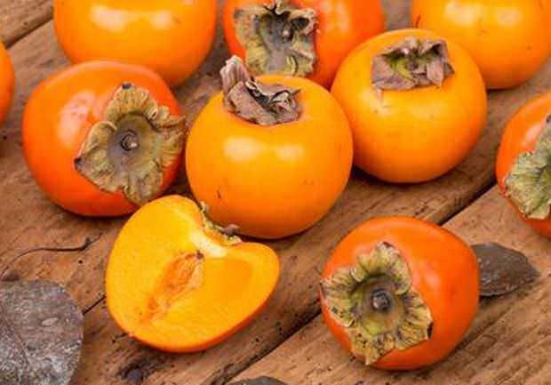 Persimone matura su tavola di legno, frutta fresca e dolce, ideale per ricette healthy e dessert naturali. Ricerca di immagini di frutta di stagione per alimenti sani e nutrienti.