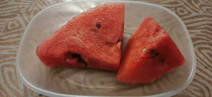 Frutti esotici top 23 dal mondo sulla tavola 4 Due fette triangolari di anguria fresca su un piatto bianco