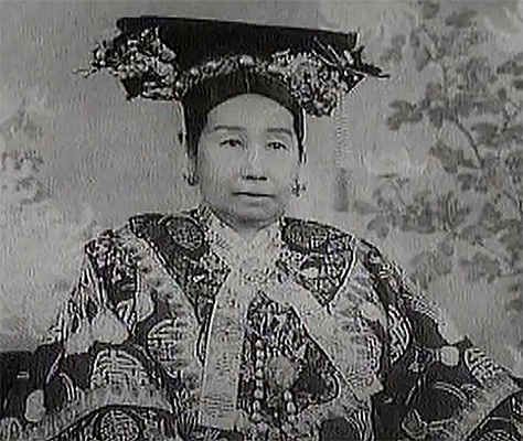 Una donna in abiti tradizionali giapponesi, con un cappello decorativo, in posa davanti a uno sfondo floreale, in stile vintage.