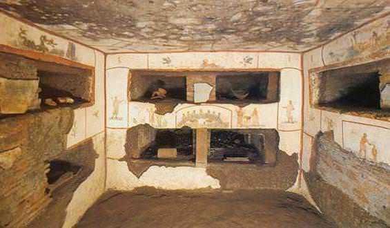 Antico sito archeologico di Roma antica con pavimentazione in pietra e resti di colonne, immerso nel verde di pino marittimo e cipressi, esempio di archeologia e storia romana.