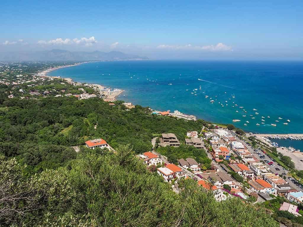 Vista panoramica della costa con mare azzurro, spiagge, insediamenti e verdeggianti colline, perfetta per appunti di viaggio o blog di turismo costiero e natura.