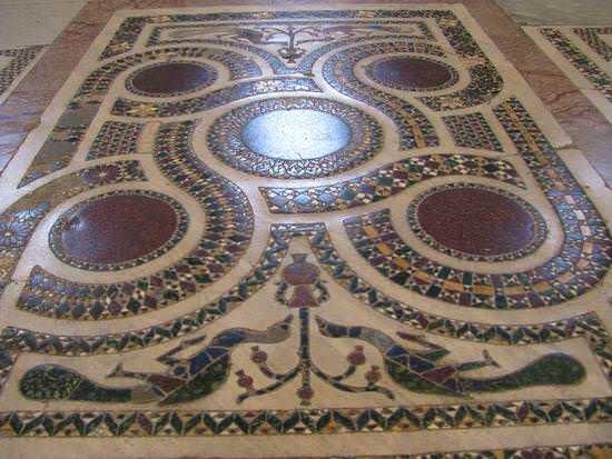Antico mosaico romano con tessere di pietra colorata e disegni geometrici, esempio di arte e artigianato dell'antichità, decorazione di pavimenti storici.