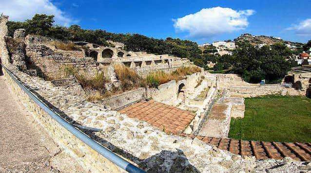 Antica rovina romana con archi e resti di edifici storici in un sito archeologico all'aperto.