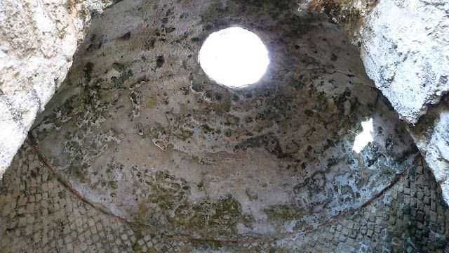 Fresca immagine di un antico pozzo di pietra con foro superiore, esposizione alla luce naturale e storia architettonica originale. Ideale per appunti sul blog dedicati a archeologia e storia antica.
