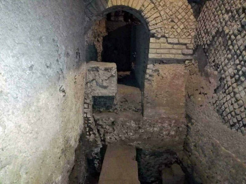 Weekend a Napoli, 12 consigli per svagarsi in 2 giorni 7 Motivo di una vecchia struttura in mattoni e pietra, probabilmente parte di un sito storico o archeologico con un arco e passaggi sotterranei, evidenziando l'architettura antica e il restauro conservativo.
