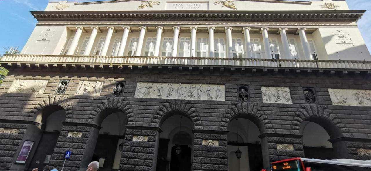 Palazzo storico con colonne e bassorilievi in centro a Napoli, Italia.