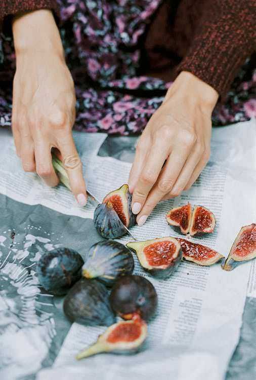 Fichi freschi e maturi pronti per essere gustati, tagliati su carta da giornale, atmosfera naturale e autentica, ideale per articoli su frutta, salute e alimentazione sana, perfetto per promozione alimentare.