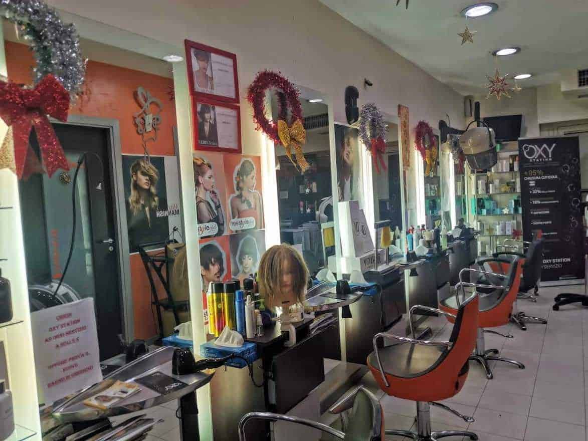 Aprire un salone da parrucchiere: Pettinature e servizi di bellezza in un salone di parrucchiere decorato per il Natale con decorazioni festive e specchi iluminati.