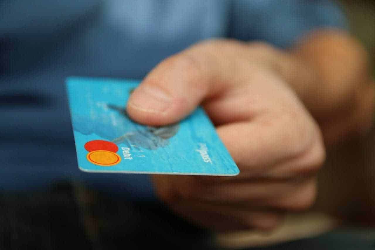 Carta di pagamento Mastercard in mano, close-up di una transazione finanziaria, concetto di pagamenti digitali e sicurezza delle carte di credito.