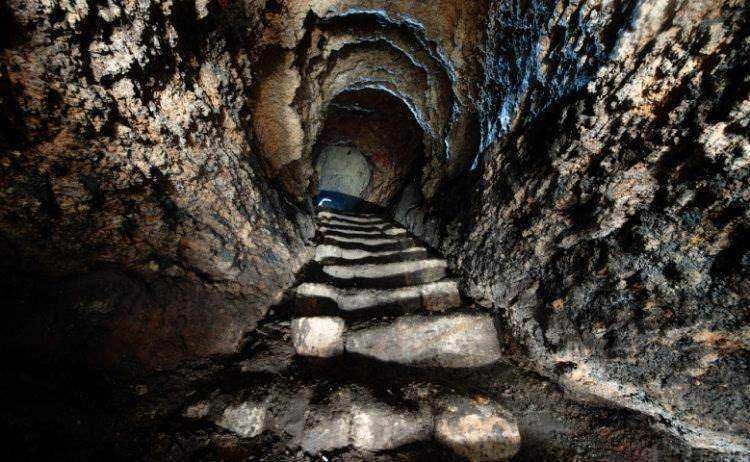Scorci di una grotta sotterranea con gradini di pietra, ambiente naturale e misterioso, ideale per esplorazioni e avventure speleologiche in Italia.