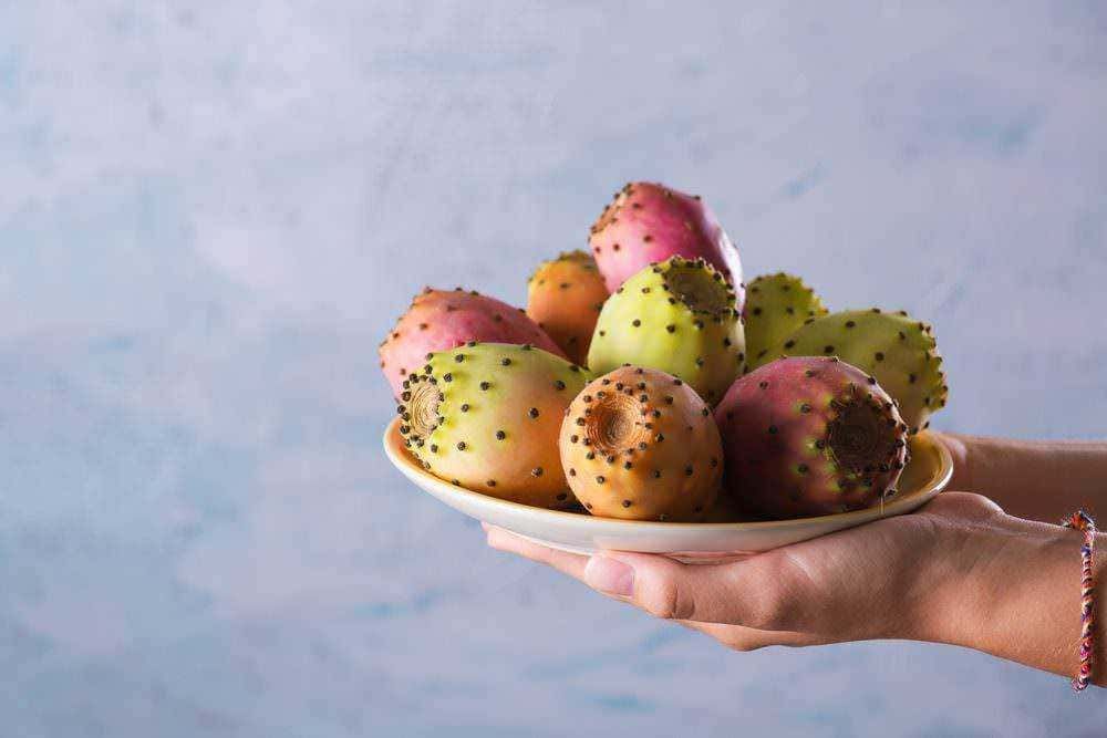Papaya fresca e succosa con semi neri e bianchi, vista dettagliata di metà frutto collocato su un tavolo in stile rustico con tovaglia colorata, alimenti tropicali sani e deliziosi.