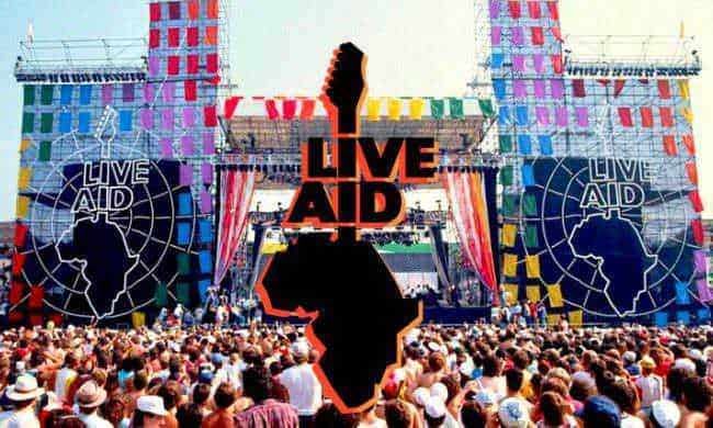 Sbarco sulla luna: Live Aid concert in Africa, with large crowd and colorful stage banners celebrating music charity event for Africa relief.
