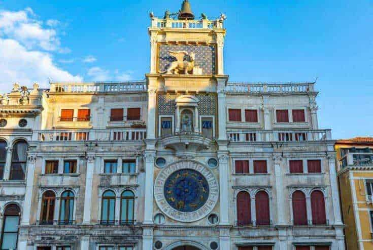 Campanile di Venezia con orologio storico e dettagli architettonici eleganti in stile rinascimentale, ambientato in una luminosa giornata di sole.