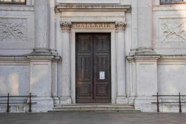 Porta d'ingresso di una galleria d'arte in stile classico, con dettagli architettonici decorativi e scritta "GALLERIE" sopra l'entrata.