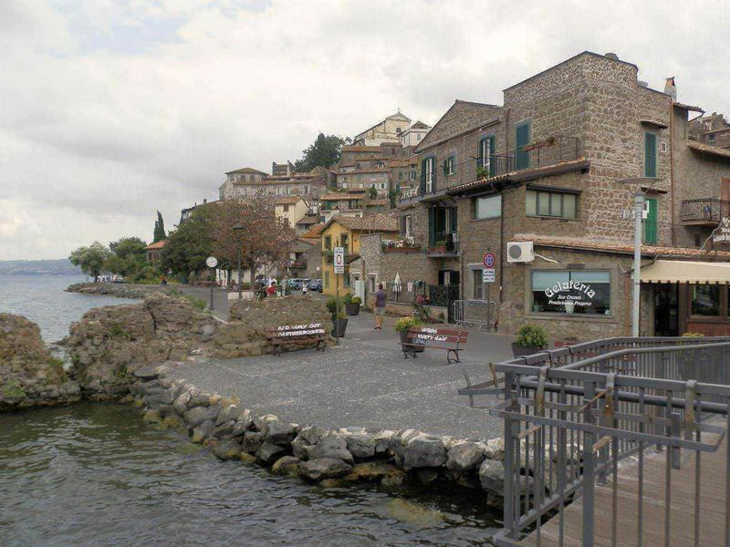 13 città da vedere vicino Roma nel Lazio meridionale 7 Vicoli colorati di un borgo italiano con chiesa storica in collina verdeggiante.