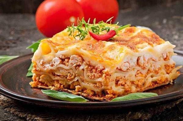 Cacio e pepe: Farcita di verdure e formaggio, rotolo di pita con rucola, aglio e formaggio, di fronte a insalate di pasta fresca, lasagne di carne, e piatti di pasta tradizionale italiana in una rivendita di cibo italiana.