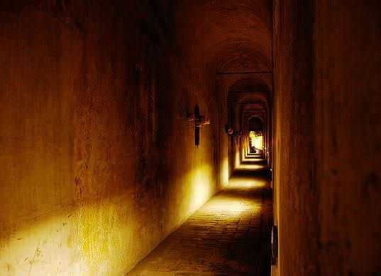 Corridoio con luci soffuse e pareti in pietra, atmosfera suggestiva e tranquilla, perfetto per passeggiate rilassanti e momenti di introspezione.