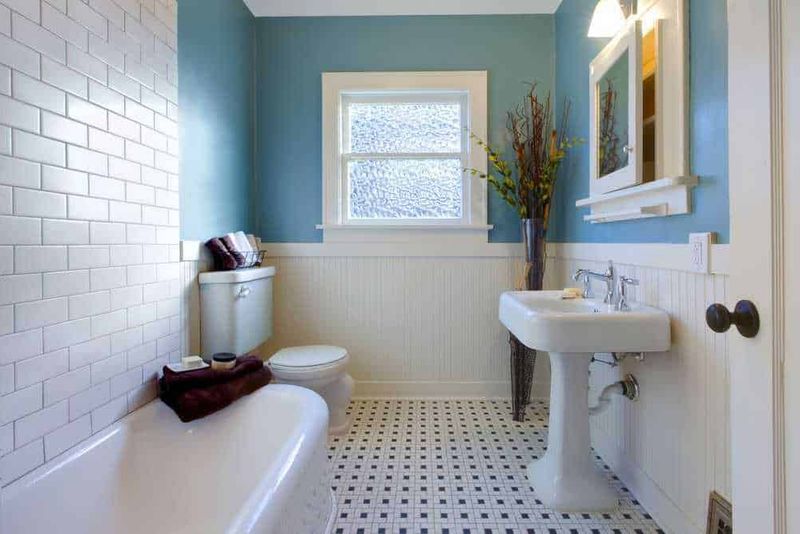 I colori più belli per la tua casa, tendenze 2023 7 Bagno con pareti azzurre e dettagli bianchi, lavabo e finestra per un ambiente luminoso e accogliente. Arredo semplice e decorazioni floreali creano un'atmosfera rilassante e pulita.