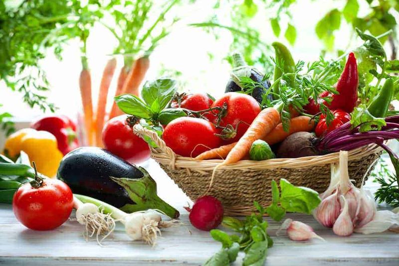 Spesa conveniente e sostenibile con il supermercato Esselunga 2 Spesa sostenibile e conveniente: Pomodori, carote, melanzane e aglio freschi in un cesto di vimini, verdure biologiche e di stagione su superficie di legno, ideali per cucina sana e ricette vegetariane healthy food, agricoltura sostenibile.